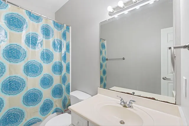 a bathroom with a sink and mirror with toilet