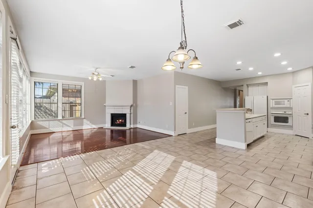a view of a kitchen with a sink and a fireplace wooden floor and chandelier