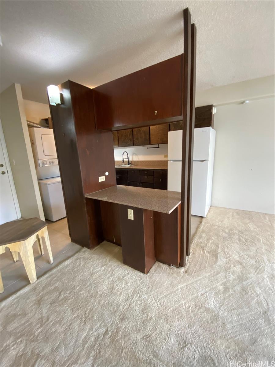 1333 Heulu Street, Unit 504 Honolulu, HI 96822 - Photo 3 of 7 a kitchen with stainless steel appliances kitchen island hardwood floor