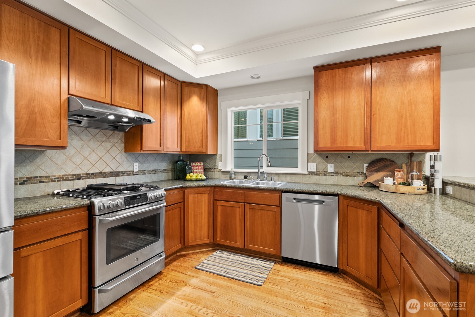121 21st Avenue East, Unit C Seattle, WA 98112 - Photo 14 of 38 a kitchen with stainless steel appliances granite countertop hardwood floor sink stove and granite counter top