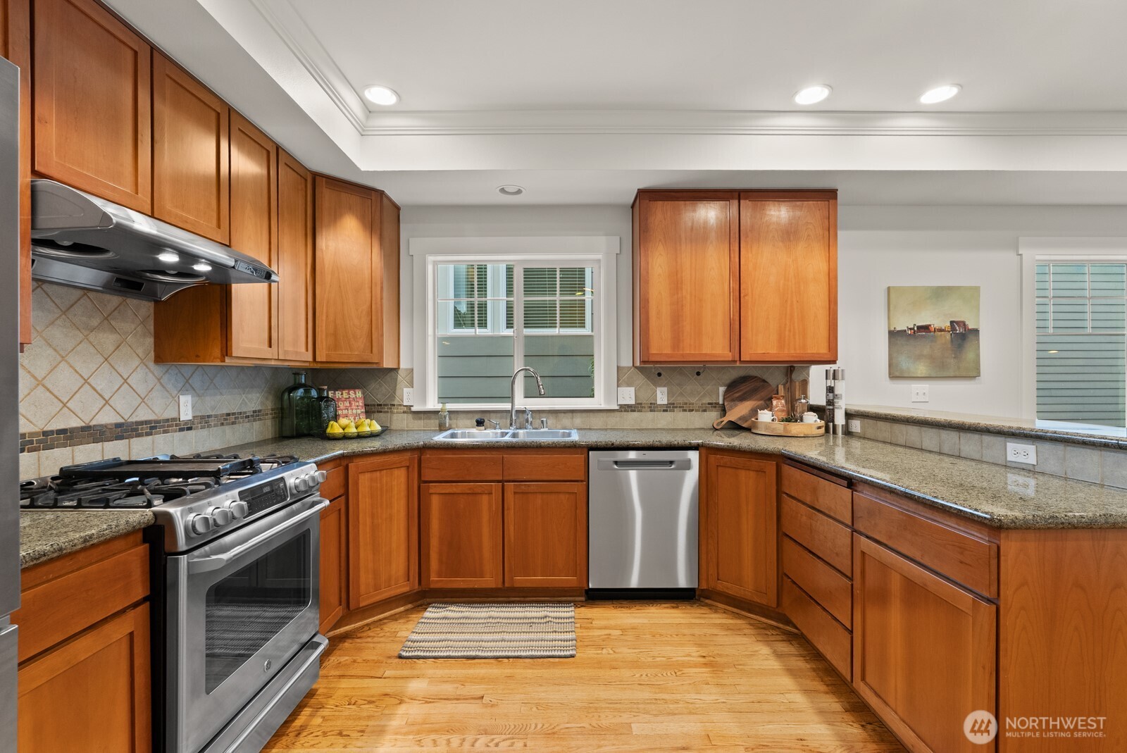 121 21st Avenue East, Unit C Seattle, WA 98112 - Photo 15 of 38 a kitchen with stainless steel appliances granite countertop wooden cabinets stove top oven and sink