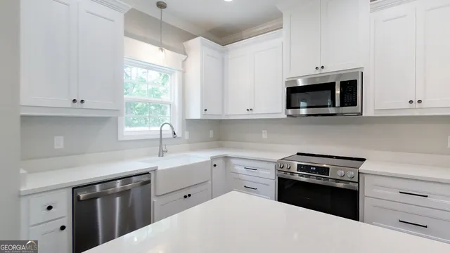 a kitchen with white cabinets and white appliances