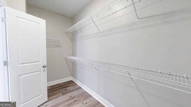 a view of walk in closet with wooden floor