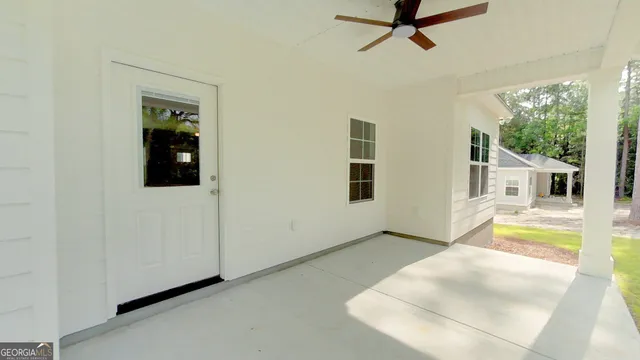 a view of a livingroom with a flesh screen tv and window