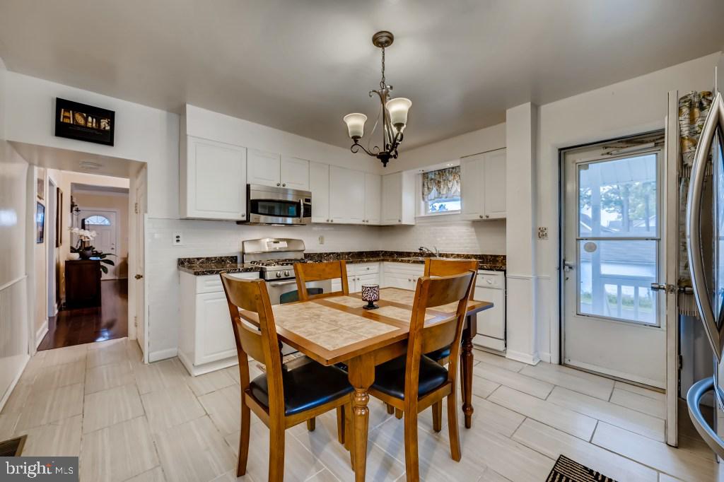 9422 Cross Road Nottingham, MD 21236 - Photo 13 of 31 a kitchen with stainless steel appliances granite countertop a sink a stove a dining table and chairs