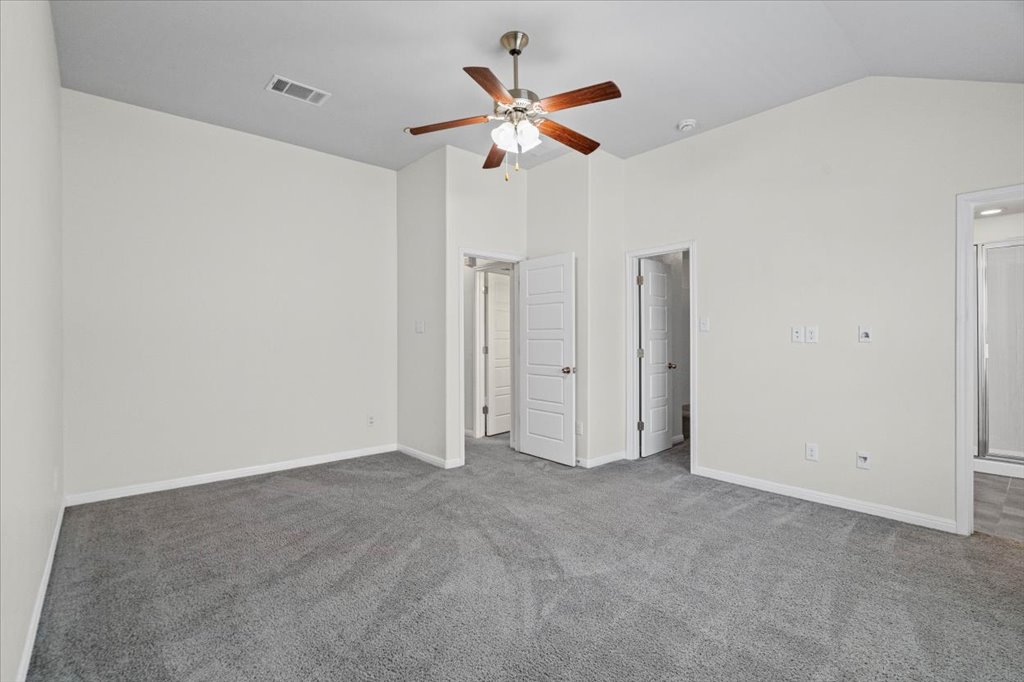 1502 Airedale Road, Unit 2502 Austin, TX 78748 - Photo 18 of 28 A comfortable bedroom with vaulted ceilings, plush carpeting, and direct access to a private bathroom.