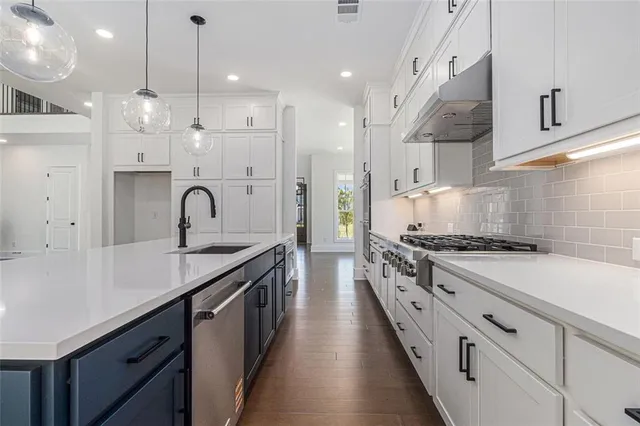 a kitchen with stainless steel appliances a sink stove and cabinets