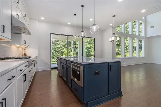 a kitchen with stainless steel appliances granite countertop a stove and a large window
