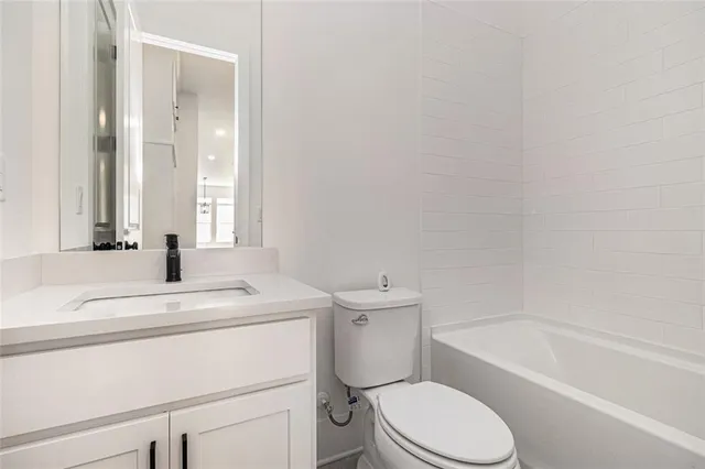 a bathroom with a sink toilet vanity and bathtub