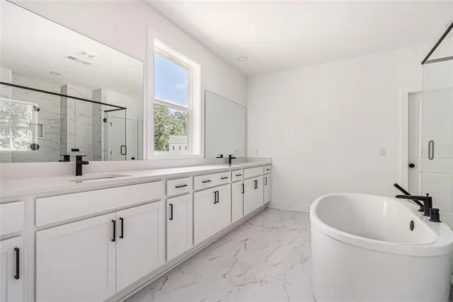 workspace with double vanity sink a mirror and a bathtub