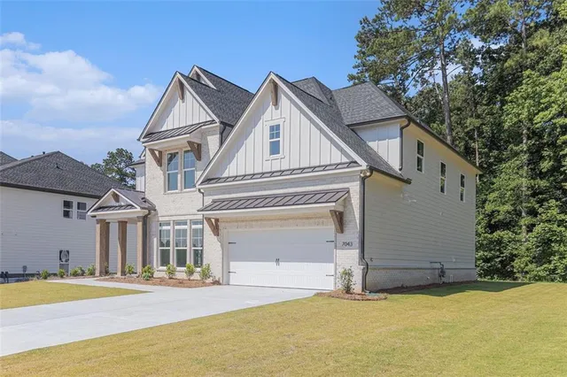 a view of a white house with a large windows and palm trees