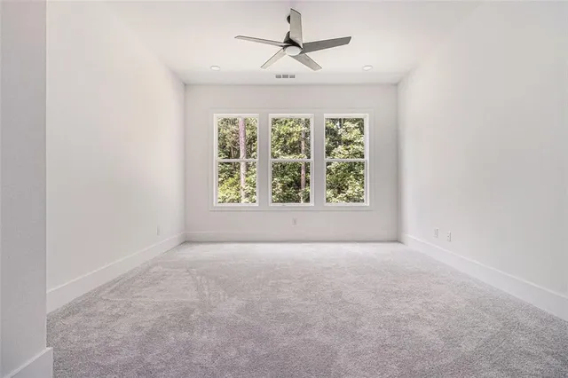 an empty room with a window and a ceiling fan