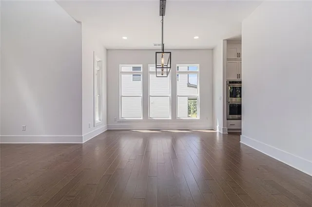 a view of empty room with wooden floor and window