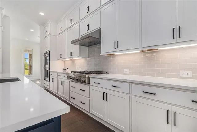 a kitchen with granite countertop white cabinets and a sink
