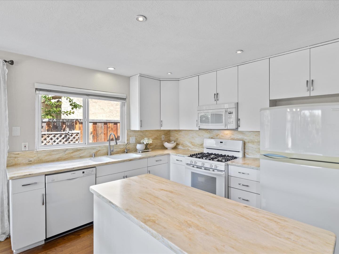 617 Lewis Road San Jose, CA 95111 - Photo 16 of 31 a kitchen with white cabinets appliances and a window