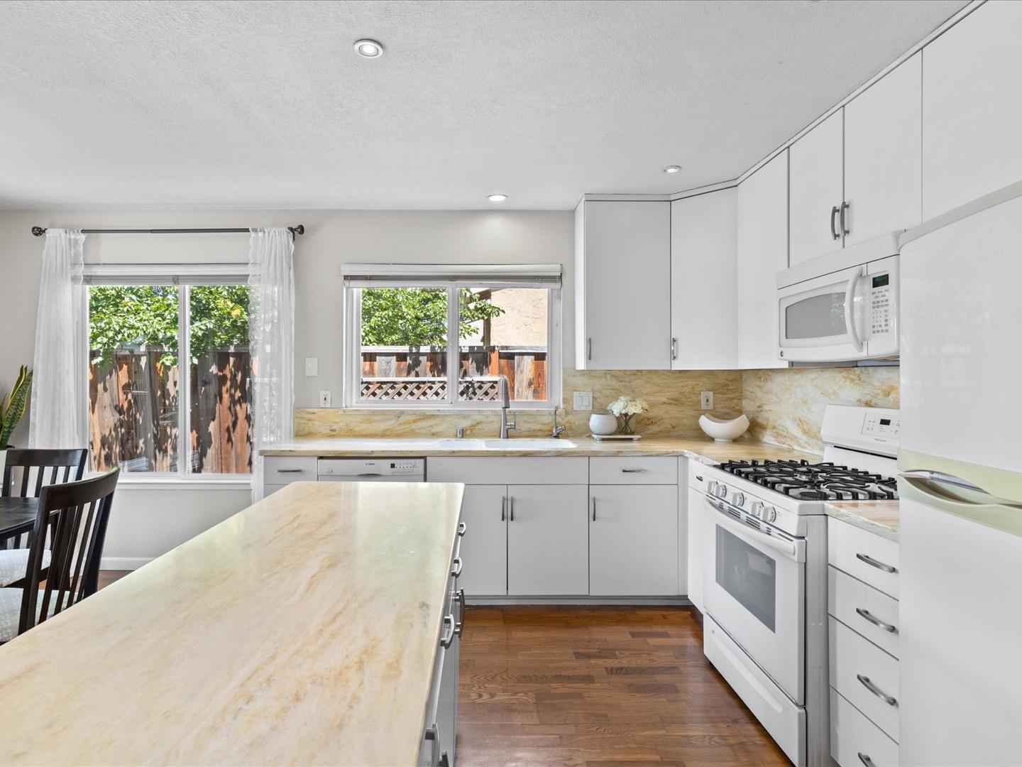 617 Lewis Road San Jose, CA 95111 - Photo 18 of 31 a kitchen with granite countertop a stove a sink and white cabinets with wooden floor
