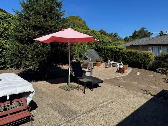 a view of a patio with a table and chairs under an umbrella