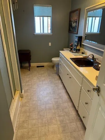 a kitchen with a sink and chairs
