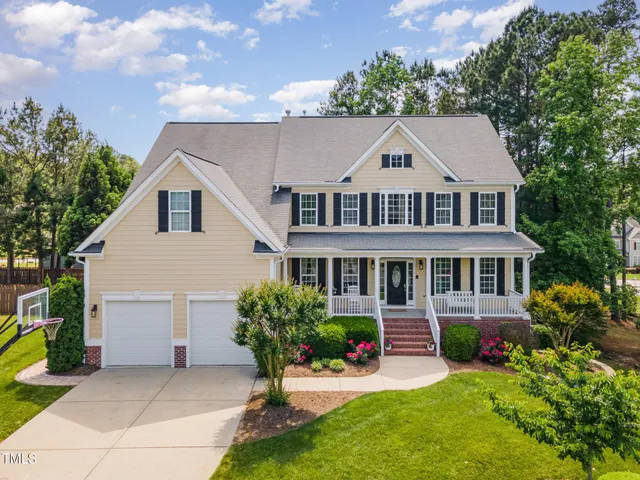 a front view of a house with a yard and potted plants