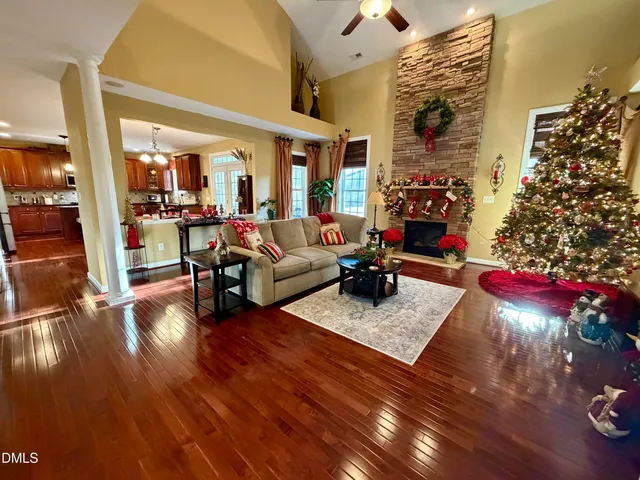 a living room with furniture hard wood floor and a floor to ceiling window
