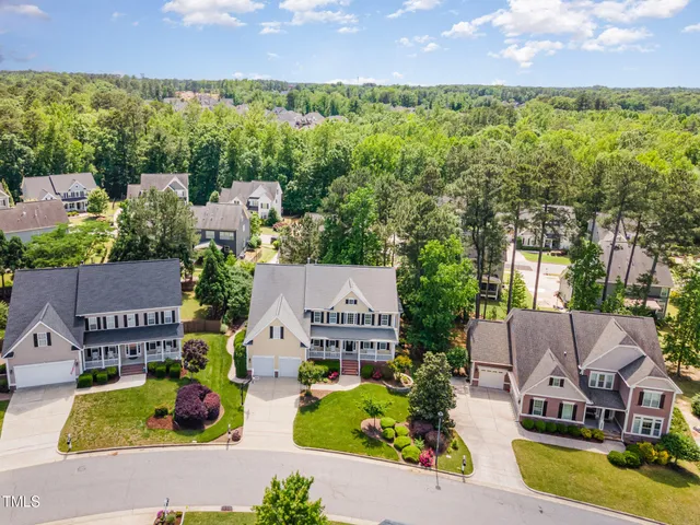 an aerial view of a house with a garden and lake view