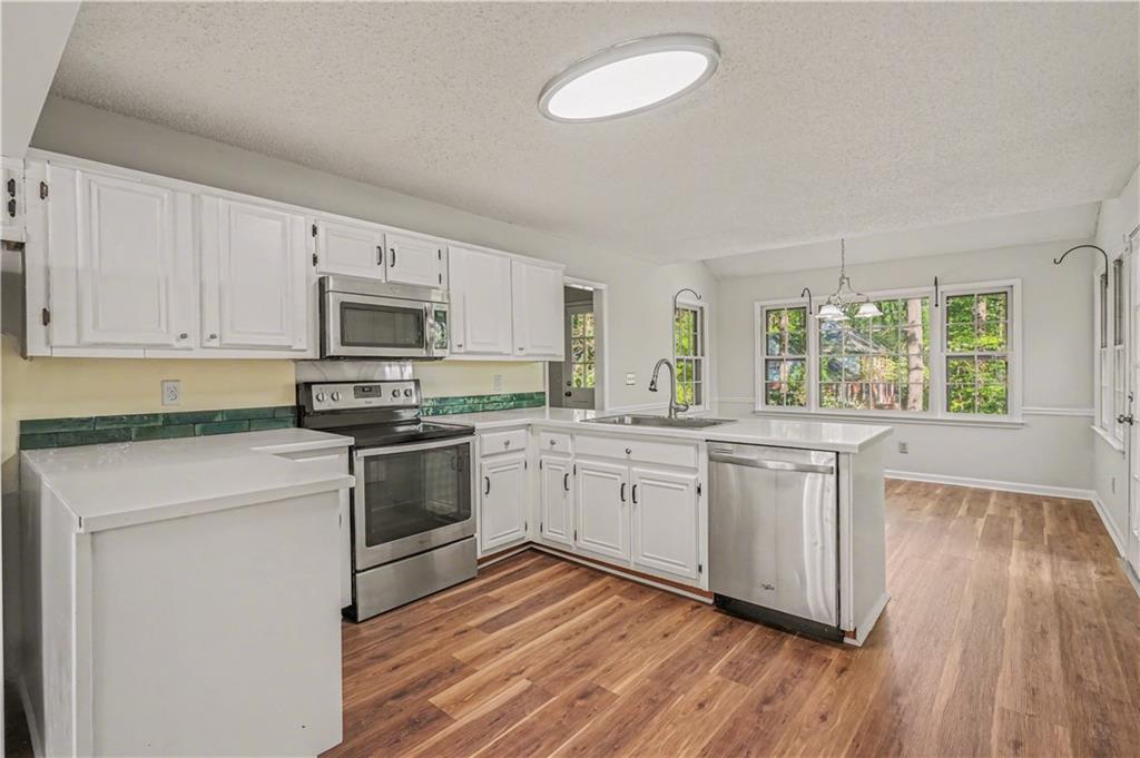 1527 Ridgewood Drive Southwest Lilburn, GA 30047 - Photo 11 of 19 a kitchen with granite countertop white cabinets and white appliances