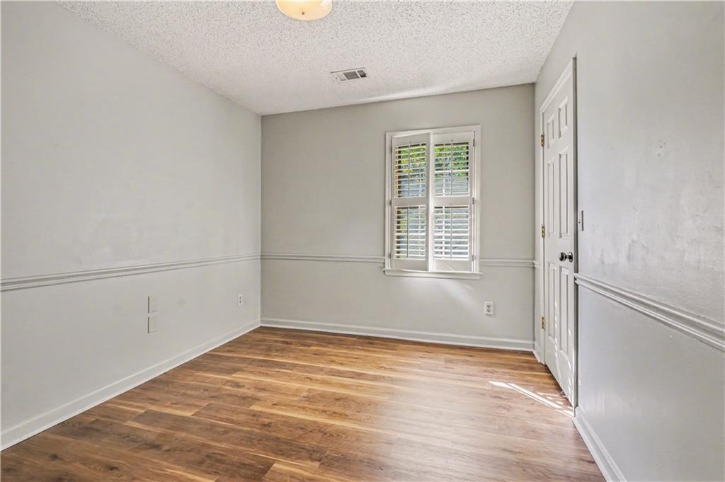 1527 Ridgewood Drive Southwest Lilburn, GA 30047 - Photo 17 of 19 an empty room with wooden floor and windows