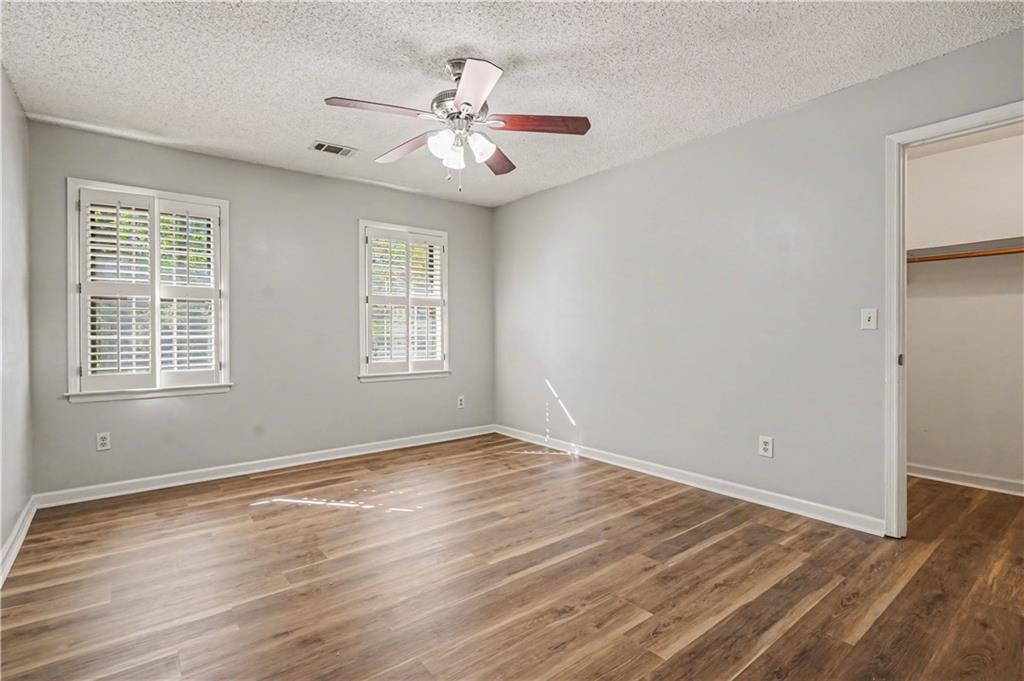 1527 Ridgewood Drive Southwest Lilburn, GA 30047 - Photo 18 of 19 a view of an empty room with wooden floor and a window