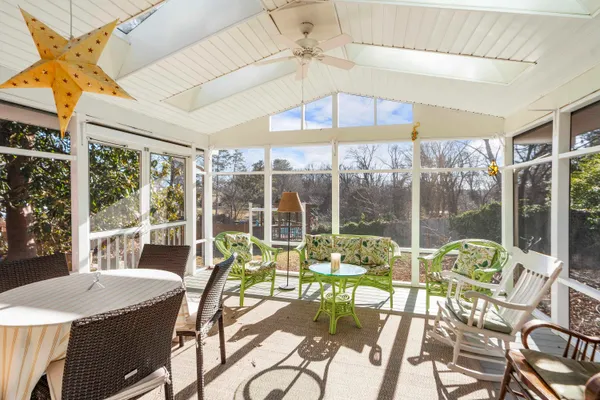 a dining room with furniture water view and a floor to ceiling window
