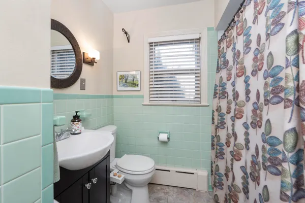 a bathroom with a sink a toilet and a mirror
