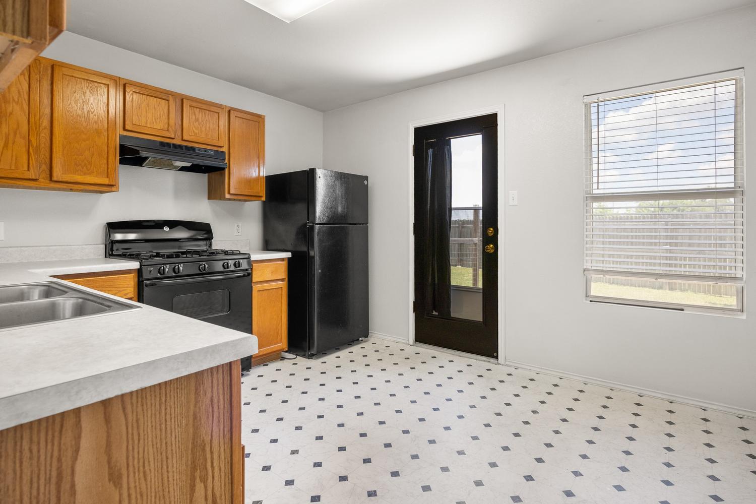 359 Spring Branch Loop Kyle, TX 78640 - Photo 7 of 17 a kitchen with granite countertop a refrigerator and a stove top oven