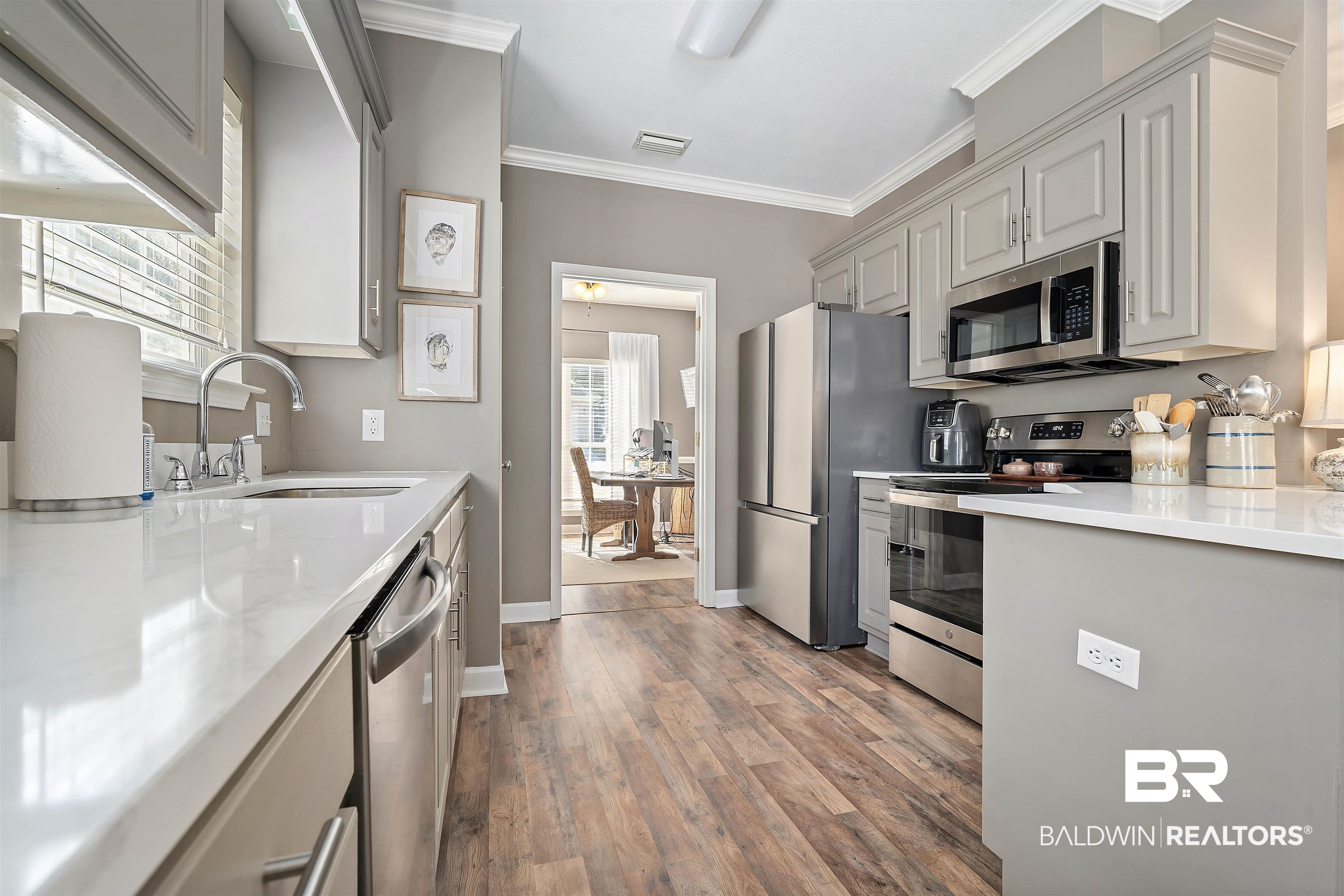 27288 Parker Lane Daphne, AL 36526 - Photo 5 of 29 Kitchen with stainless steel appliances, plenty of natural light, crown molding, light stone counters, and light wood-style floors