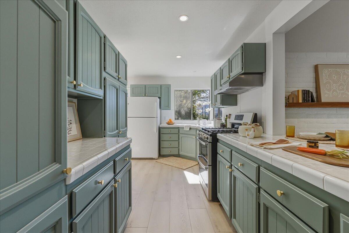 674 Chalk Hill Road Solvang, CA 93463 - Photo 26 of 52 a kitchen with a sink a refrigerator and cabinets