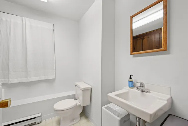 a bathroom with a sink a toilet and mirror