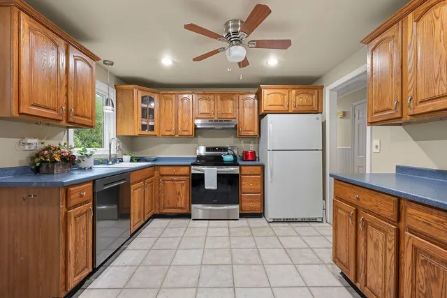 a kitchen with a refrigerator a stove top oven and cabinets