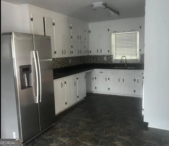 a kitchen with granite countertop a refrigerator and a sink