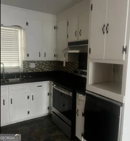 a kitchen with granite countertop white cabinets and black appliances