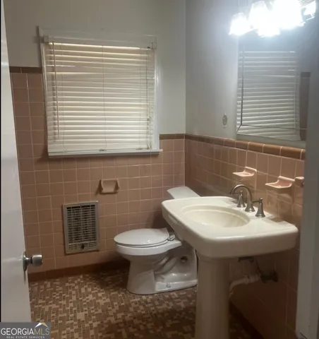 a bathroom with a sink a toilet and a mirror