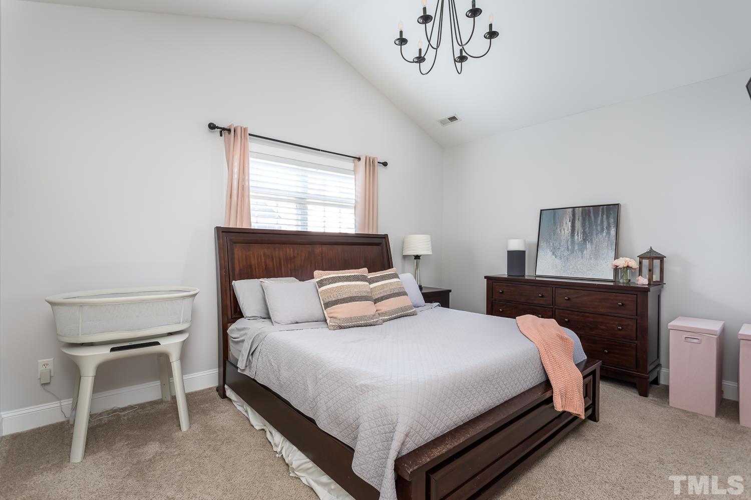 1233 North Blount Street Raleigh, NC 27604 - Photo 21 of 42 a bedroom with a bed and a chandelier