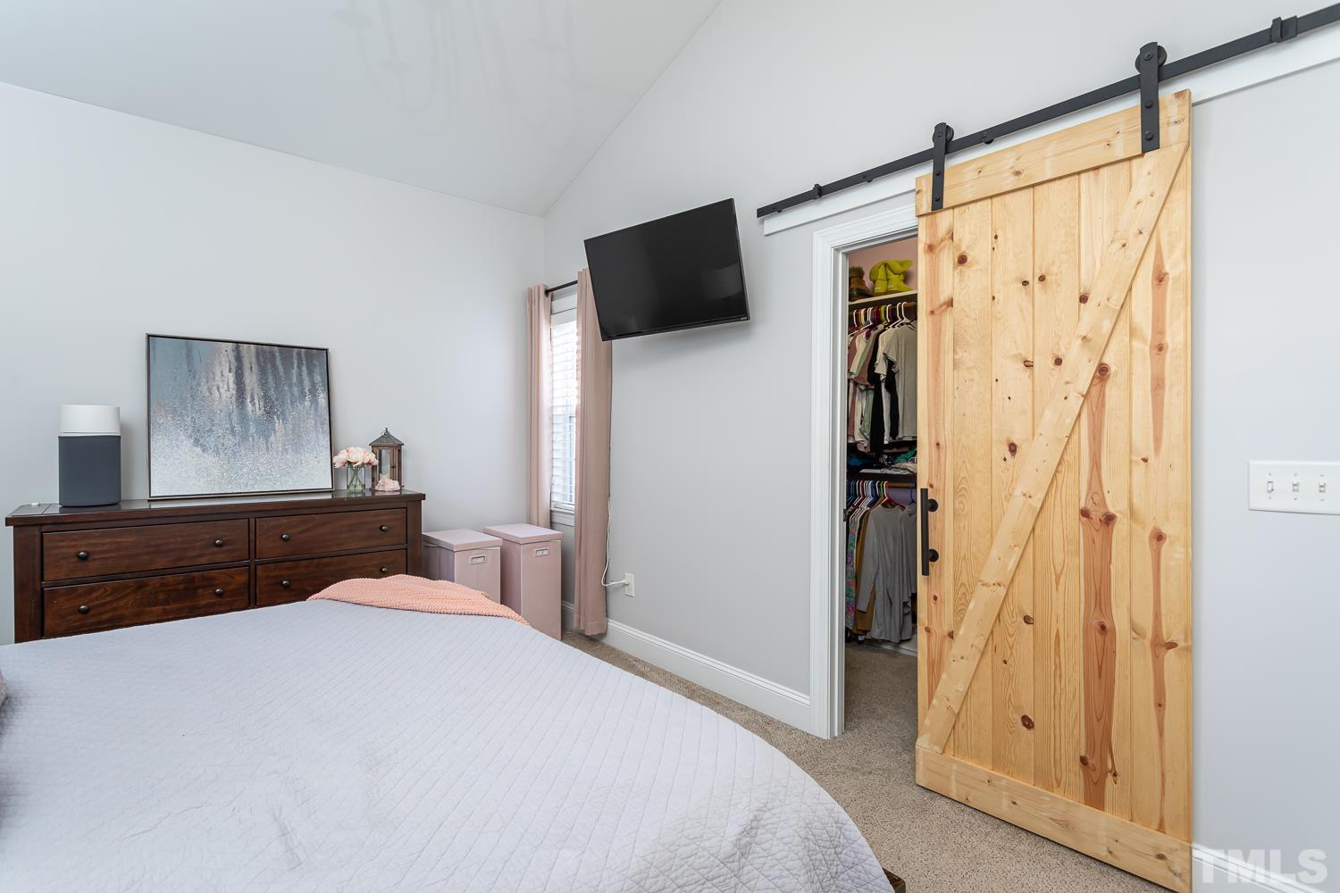 1233 North Blount Street Raleigh, NC 27604 - Photo 22 of 42 a bedroom with a bed and a flat tv screen on dresser