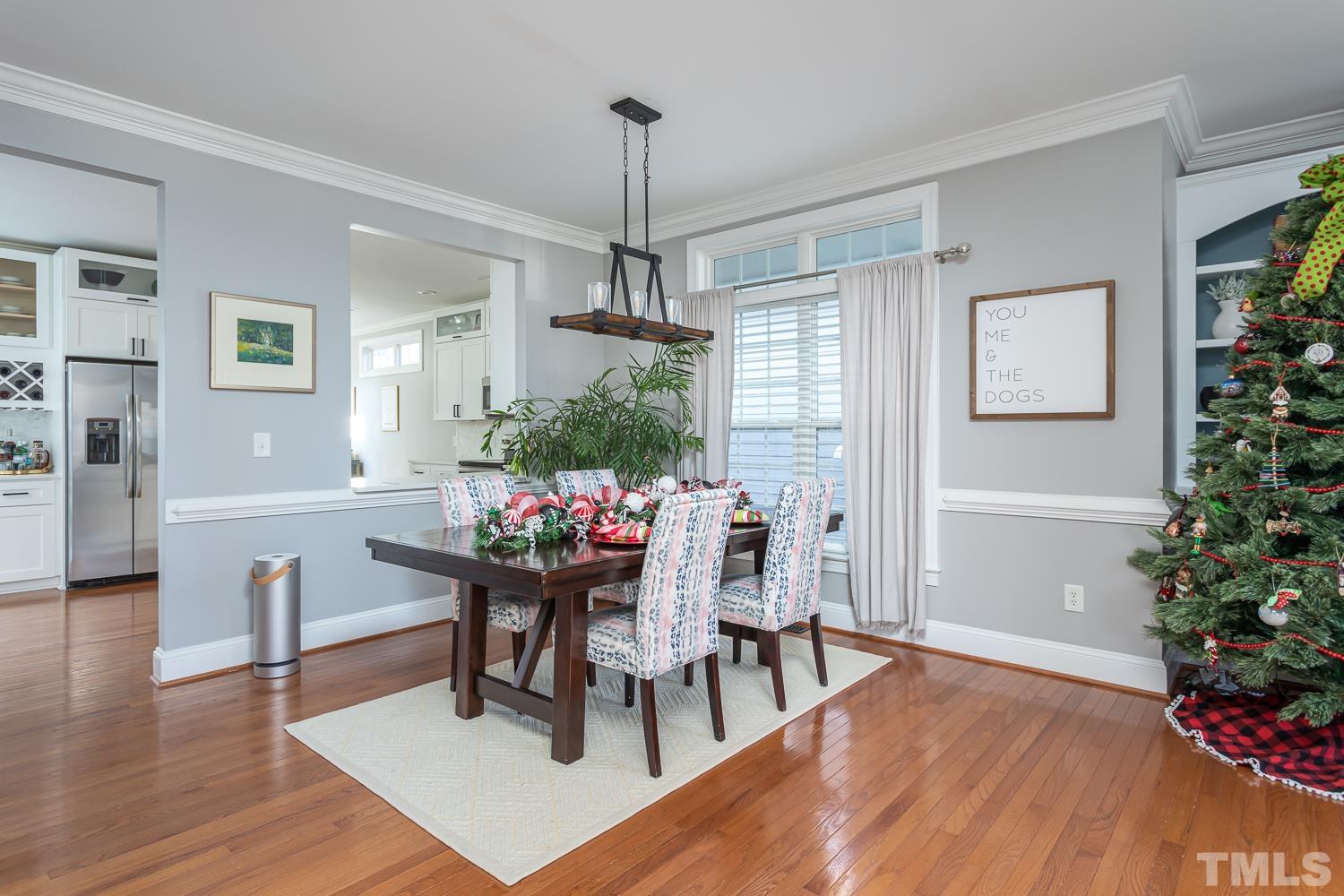 1233 North Blount Street Raleigh, NC 27604 - Photo 7 of 42 a dining room with wooden floor a chandelier a wooden table and chairs