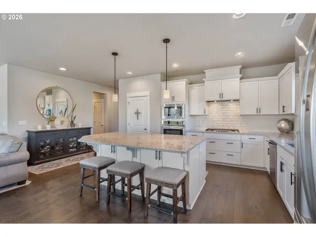 a kitchen with white cabinets and chairs