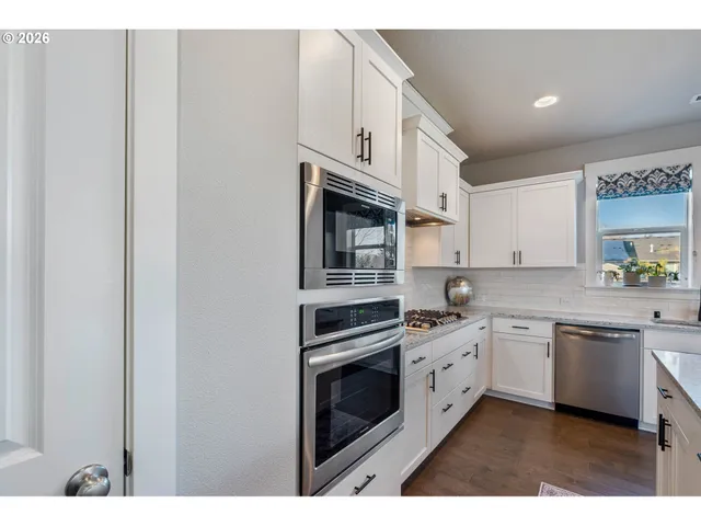 a kitchen with stainless steel appliances granite countertop a stove a sink and a microwave