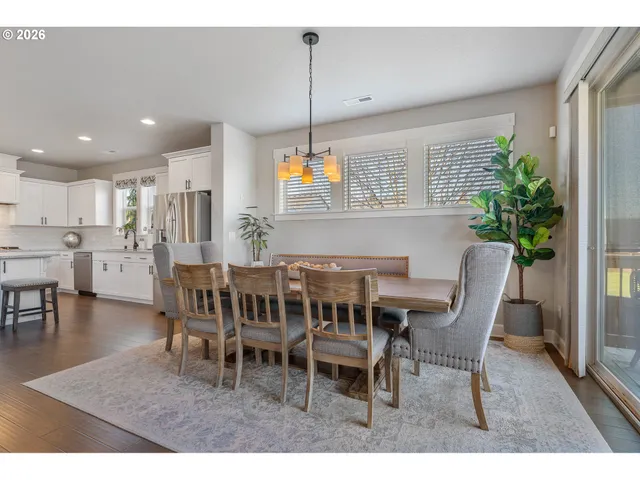 a dining room with furniture potted plants and wooden floor