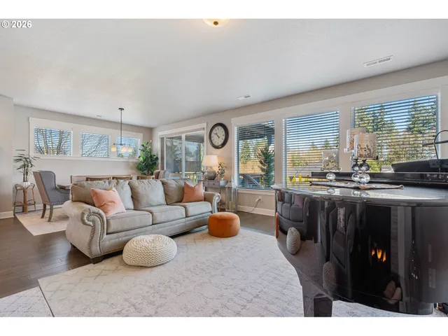 a living room with furniture a large window and a dining table