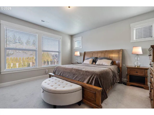 a bedroom with a bed mirror and window