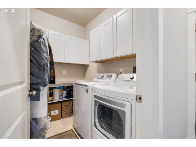 a view of washer and dryer with kitchen in the background