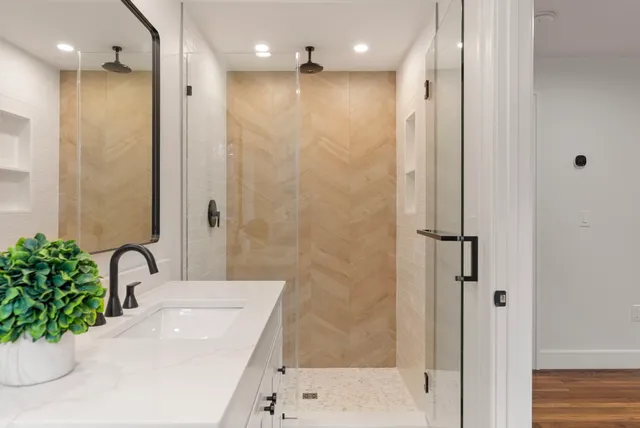 a bathroom with a sink shower and a mirror