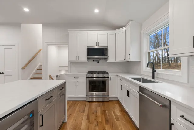 a kitchen with a sink stove top oven and cabinets