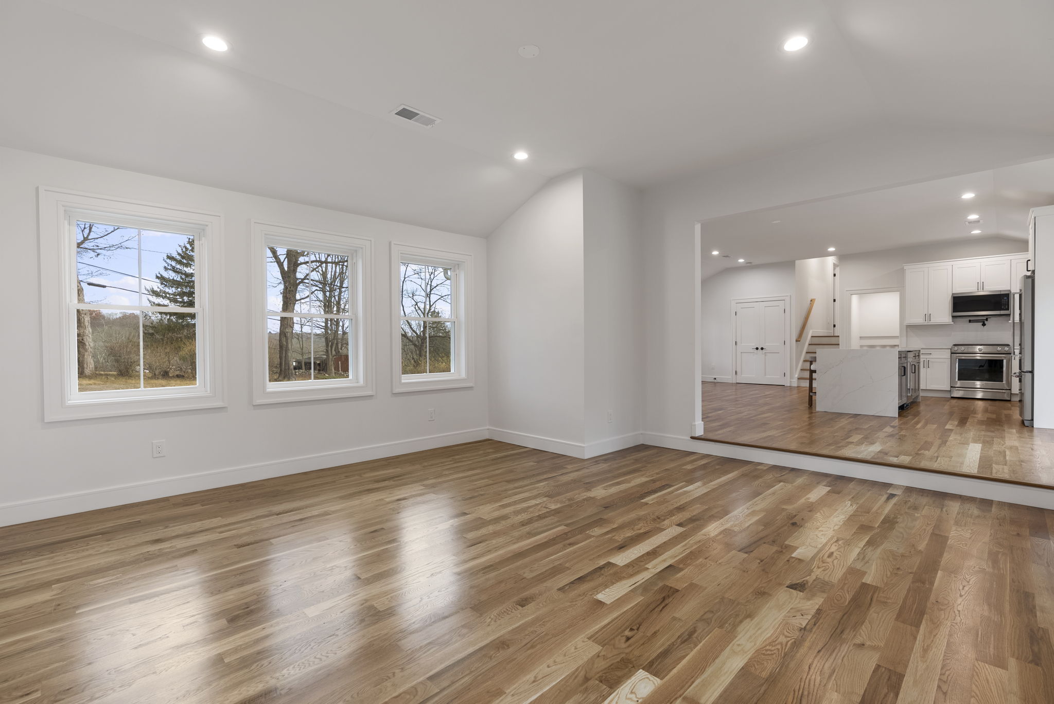 52 Curtis Road Bridgewater, CT 06752 - Photo 10 of 25 This sunken family room addition boasts soaring 9+ ft ceilings, new hardwood floors, and abundant natural light from new windows, creating an open, inviting space perfect for relaxing, entertaining, or family gatherings.